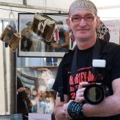 Peter ontbreekt natuurlijk niet op de Harleydag. Hier staat hij bij de stand van Judesign, op de achtergrond foto\'s van Peter en Judesign-producten waarin foto\'s zijn verwerkt.